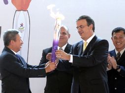 Marcelo Ebrard (derecha) recibe la llama olímpica de manos de Ng Ser Miang. NTX  /