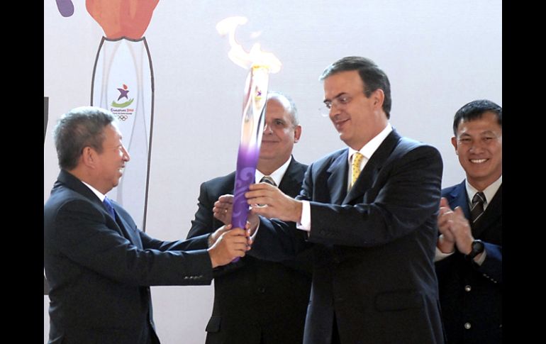 Marcelo Ebrard (derecha) recibe la llama olímpica de manos de Ng Ser Miang. NTX  /