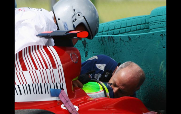 Personal médico intenta retirar del habitáculo a Felipe Massa luego del percance. AFP  /