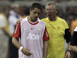 Javier Hernández recibe consejos del técnico Alex Ferguson. AP  /