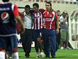 Omar Esparza (centro) es ayudado a salir del terreno de juego el viernes pasado en la inauguración del Estadio Chivas. E. PACHECO  /