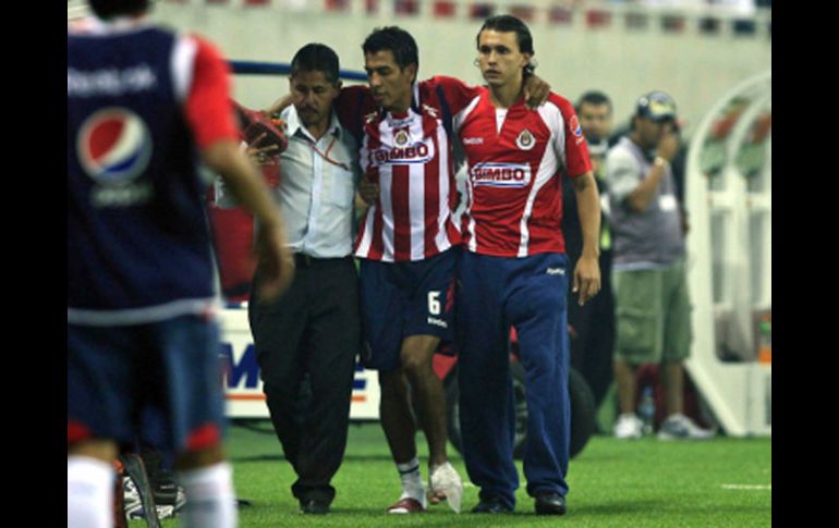 Omar Esparza (centro) es ayudado a salir del terreno de juego el viernes pasado en la inauguración del Estadio Chivas. E. PACHECO  /