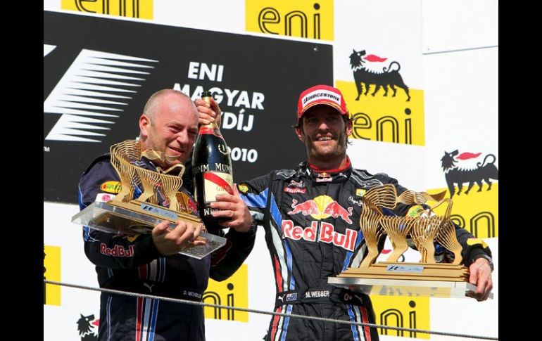 El piloto australiano Mark Webber (der.) celebra su victoria en el podio junto al mecánico de su equipo, Darren Nicholls. EFE  /