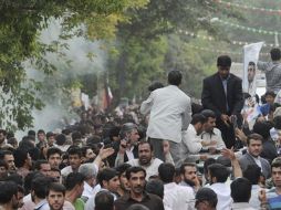 Cerca del convoy del presidente iraní Mahmoud Ahmadinejad se aprecia el humo (izquierda) del petardo que lanzó un simpatizante. AP  /