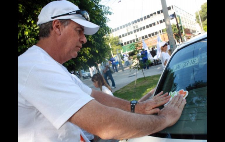 El director general del Copag, Carlos Andrade Garín pega las calcamonias de 'Yo Soy Panamerica'. A. Hinojosa  /