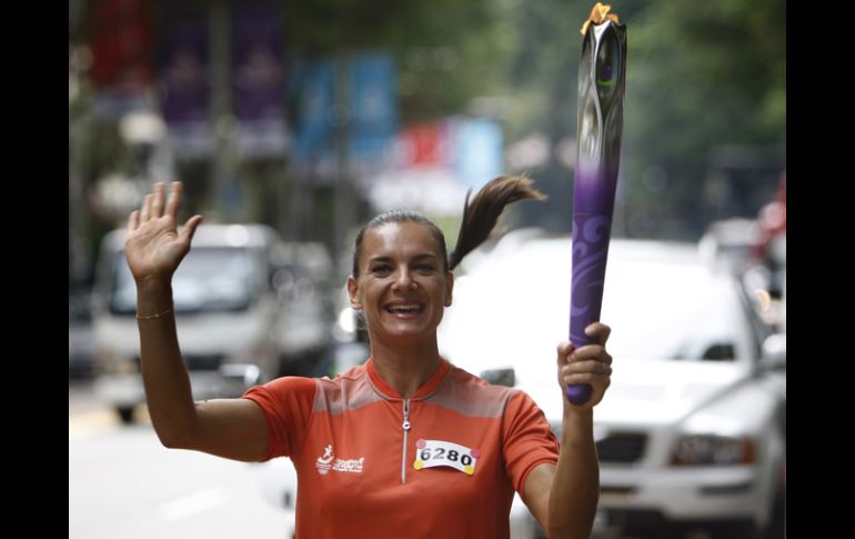 Yelena Isinbayeva, quien es embajadora de los JOJ, transportaba ayer la flama olímpica en Singapur. AP  /