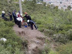 Peritos forenses y soldados realizan el levantamiento de cuerpos hallados en el acceso de una mina en Pachuca. EFE  /