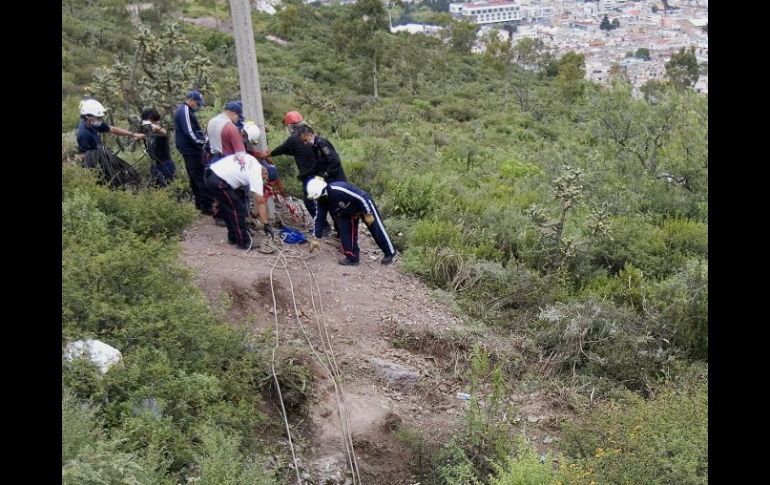 Peritos forenses y soldados realizan el levantamiento de cuerpos hallados en el acceso de una mina en Pachuca. EFE  /