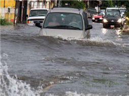 Varios automóviles transitan a través de una calle inundada por las lluvias de la tormenta tropical Danielle. EFE  /