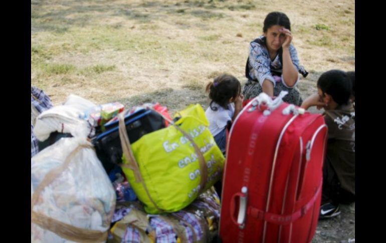 Gitanos rumanos que han llegado de Francia descansan junto a su equipaje en el aeropuerto Internacional de Bucarest. EFE  /