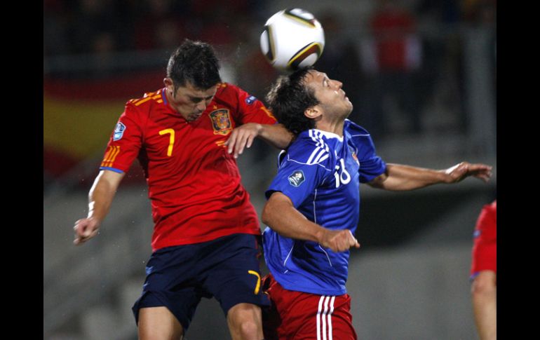 El español David Villa (der) y Philippe Erne del Liechtenstein (iz) pelean un balón en el cancha de Vaduz.AP  /