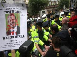 La Policía irlandesa tuvo que contener a manifestantes que intentaban derribar una barrera de seguridad montada frente al edificio. AFP  /