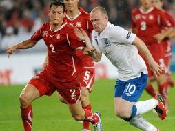 El jugador suizo Stephan Lichtsteiner (iz) disputa el balón con el inglés Wayne Rooney (der)  durante un partido de clasificación. EFE  /