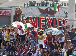 Los espectadores aprecian el desfile que pasan por las calles, en el este de Los Ángeles. AP  /