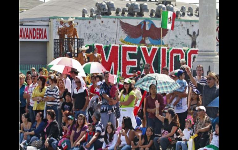 Los espectadores aprecian el desfile que pasan por las calles, en el este de Los Ángeles. AP  /