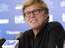 Robert Redford dejó atrás su imagen de “duro” y sonrió para las cámaras durante su presencia en Toronto. AP  /