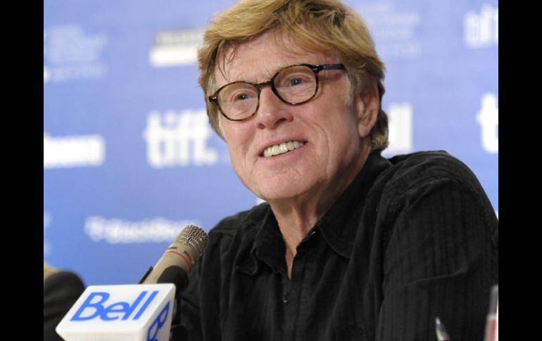 Robert Redford dejó atrás su imagen de “duro” y sonrió para las cámaras durante su presencia en Toronto. AP  /