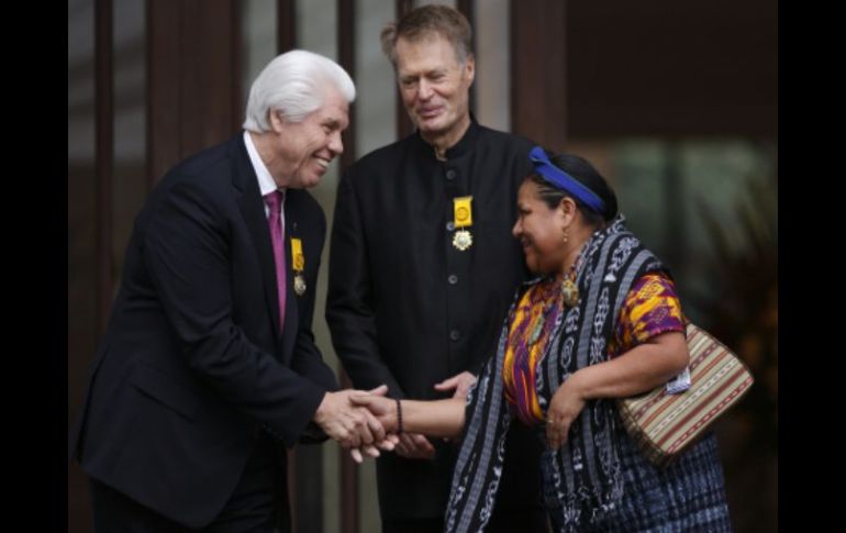 Rigoberta Menchú (d), Jean-Marie Gustave Le Clezio (c), y  William Austin (i), se saludan luego de ser condecorados. EFE  /