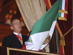 El Presidente Felipe Calderón ondea la bandera durante el Grito de la Independencia, desde el balcón de Palacio Nacional. EFE  /