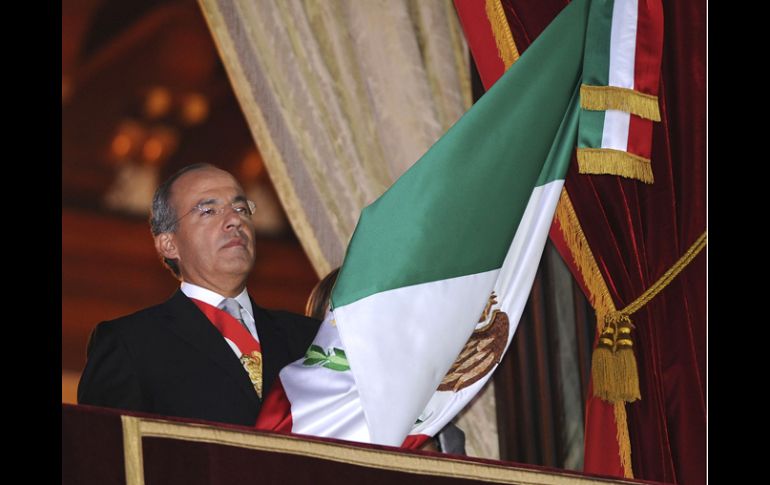 El Presidente Felipe Calderón ondea la bandera durante el Grito de la Independencia, desde el balcón de Palacio Nacional. EFE  /