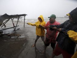 Algunos pobladores intentan reponer los daños causados por la llegada del huracán. REUTERS  /