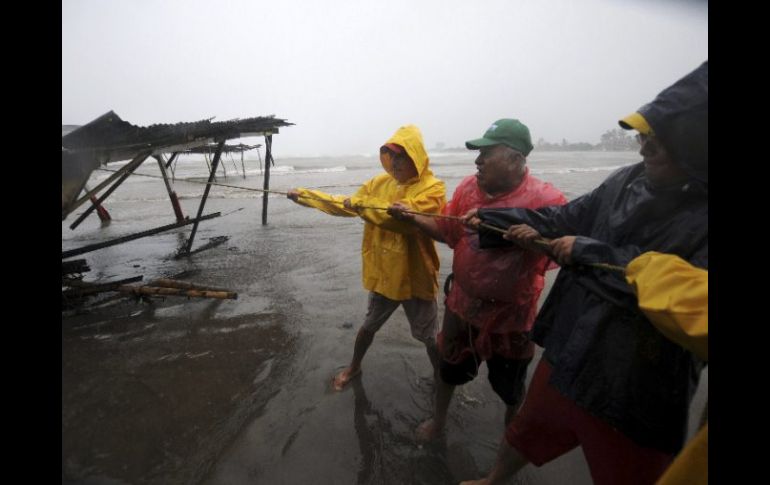 Algunos pobladores intentan reponer los daños causados por la llegada del huracán. REUTERS  /