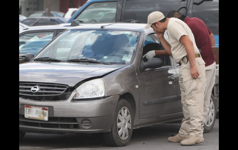 Peritos analizan el auto en que los fotógrafos fueron atacados. EFE  /