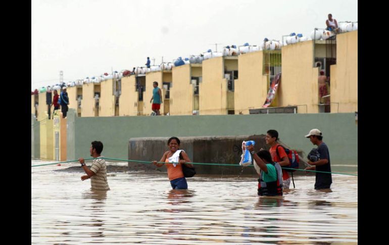 Personas salen de sus hogares inundados en un fraccionamiento de Xalapa, Veracruz. EL UNIVERSAL  /