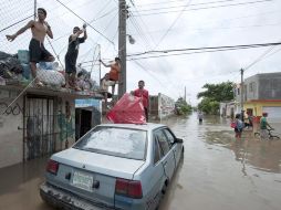 Personas en una calle inundada de la ciudad de Veracruz. AP  /