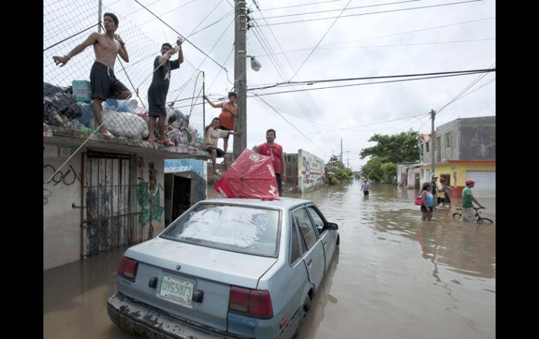 Personas en una calle inundada de la ciudad de Veracruz. AP  /