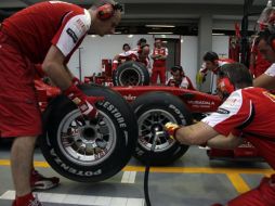 Los mecánicos de Ferrari alistan uno de sus autos para las primeras pruebas en el circuito de Singapur. AP  /