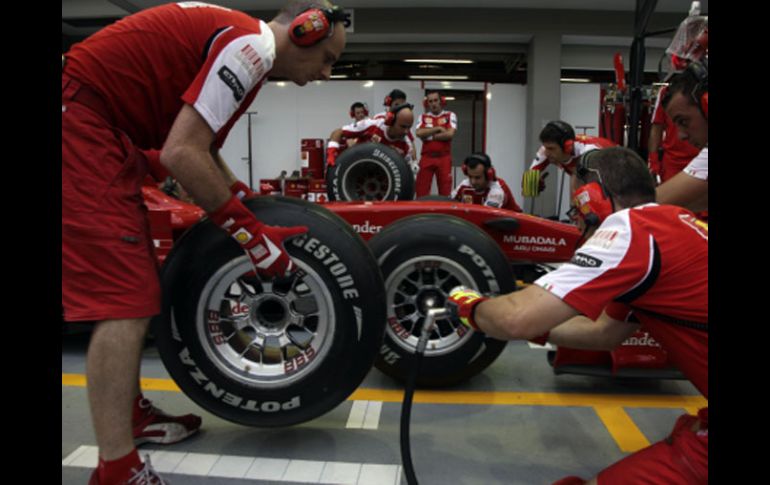 Los mecánicos de Ferrari alistan uno de sus autos para las primeras pruebas en el circuito de Singapur. AP  /