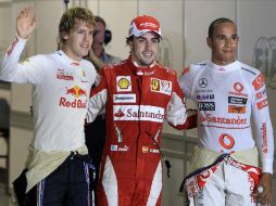 Fernando Alonso posa al término de la clasificación con Sebastian Vettel y Lewis Hamilton quienes le secundarán en la salida. AP  /