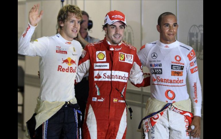 Fernando Alonso posa al término de la clasificación con Sebastian Vettel y Lewis Hamilton quienes le secundarán en la salida. AP  /