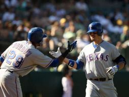 Julio Borbon (izq) celebra con Jorge Cantú (der) en juego que le dio el título a los Rangers. AFP  /