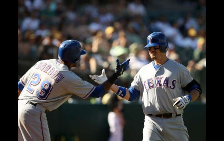 Julio Borbon (izq) celebra con Jorge Cantú (der) en juego que le dio el título a los Rangers. AFP  /