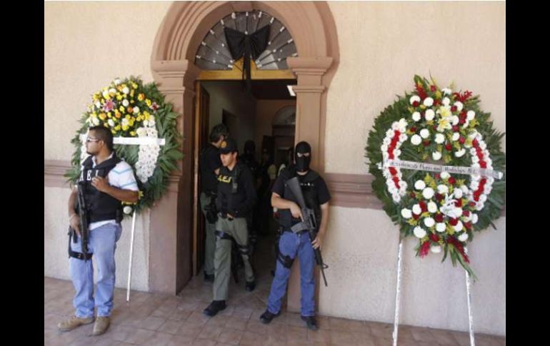 Detectives de la Policía montan guardia junto a coronas de flores para el alcalde Prisciliano Rodríguez. REUTERS  /