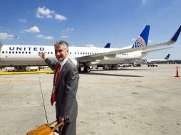 El presidente de la nueva firma, Jeff Smisek, señala uno de los aviones de la aerolínea. AP  /