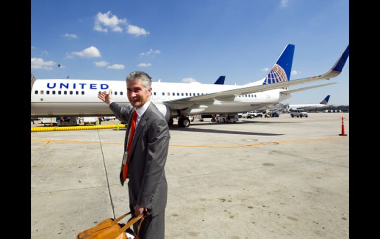 El presidente de la nueva firma, Jeff Smisek, señala uno de los aviones de la aerolínea. AP  /