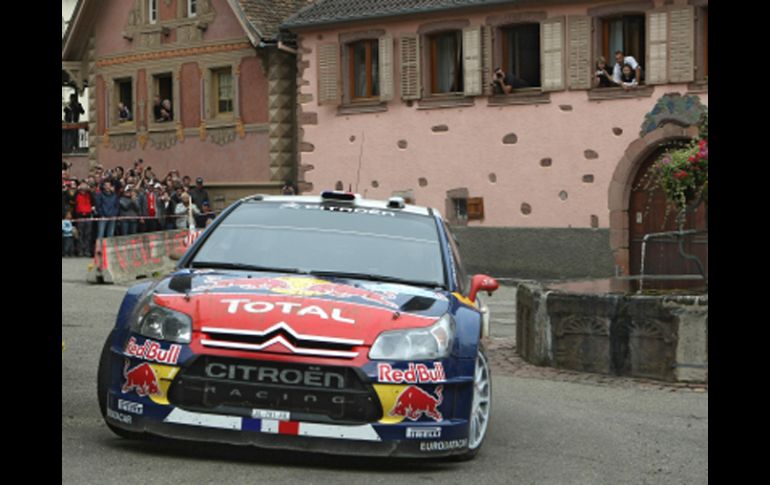 Sébastien Loeb, a bordo de su Citroën C4, pasa por la compañía francesa de su natal Alsacia, en Heiligenstein. AP  /