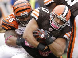 Peyton Hillis de los Marrones de Cleveland (cen) lucha con la defensa de los Bengalíes. AP  /