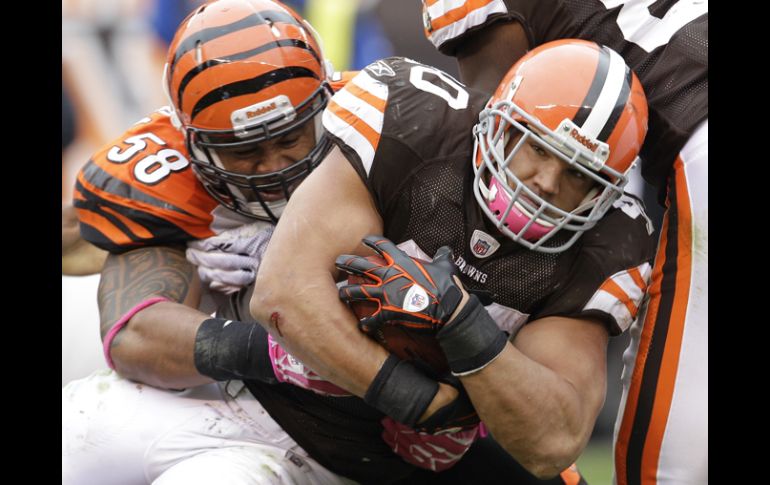 Peyton Hillis de los Marrones de Cleveland (cen) lucha con la defensa de los Bengalíes. AP  /