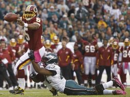 EL mariscal de campo de Pieles rojas de Washington, Donovan McNabb, arrastra  la defensiva de Águilas. AP  /