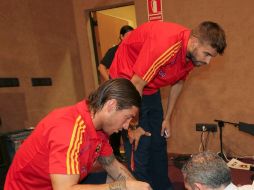 Los defensas de la selección española de fútbol Sergio Ramos izq, y Gerard Piqué, firman autógrafos antes de una rueda de prensa. EFE  /