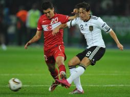 El jugador alemán Mesut Oezil antes de la lesión (der) disputa el balón con el turco Nuri Sahin. EFE  /