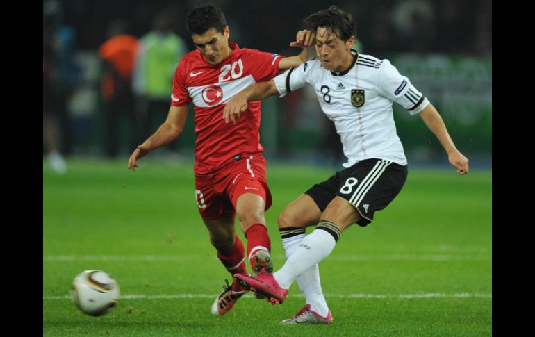 El jugador alemán Mesut Oezil antes de la lesión (der) disputa el balón con el turco Nuri Sahin. EFE  /