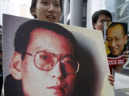 Una china sostiene la imagen del disidente y crítico literario Liu Xiaobo, a quien se otorgó el Premio Nobel de la Paz. REUTERS  /