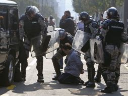 Policías antidisturbios arrestan a uno de los manifestantes que intentaba impedir la celebración de la marcha del orgullo gay. EFE  /