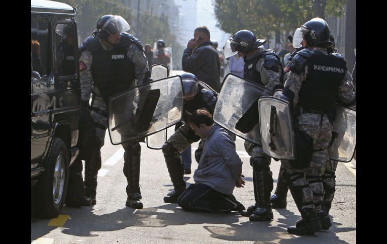 Policías antidisturbios arrestan a uno de los manifestantes que intentaba impedir la celebración de la marcha del orgullo gay. EFE  /