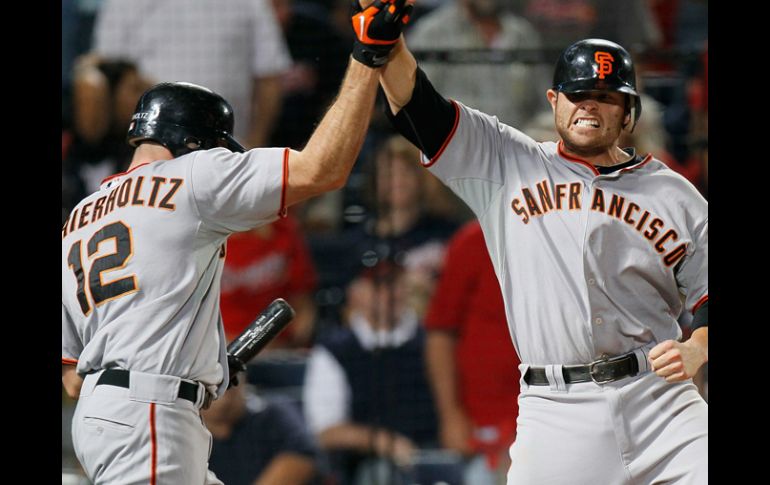 Freddy Sánchez festeja con Nate Schierholtz (12) la carrera del triunfo ante los Bravos. AFP  /